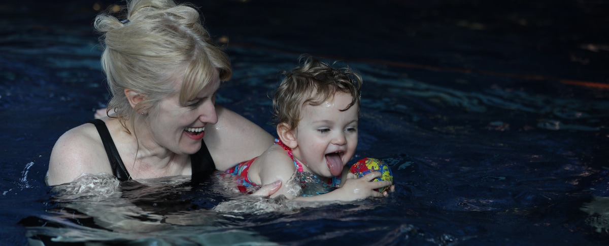 An adult and child swimming at baby swimming lessons in Greater Manchester